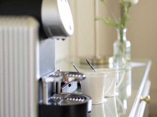 a table with two coffee cups and a lamp at Lough Erne Resort in Enniskillen