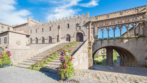 a building with stairs and flowers in front of it at La Cocca Via Saffi, con vasca in camera in Viterbo
