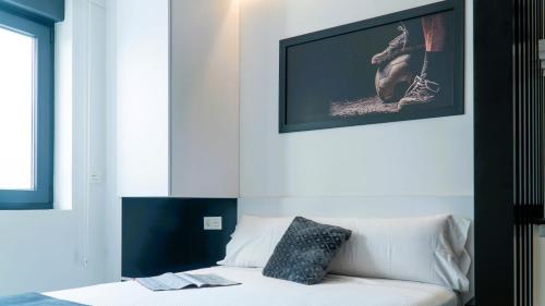 a white couch in a room with a picture on the wall at Apartamentos Identia Sport by gaiarooms in León