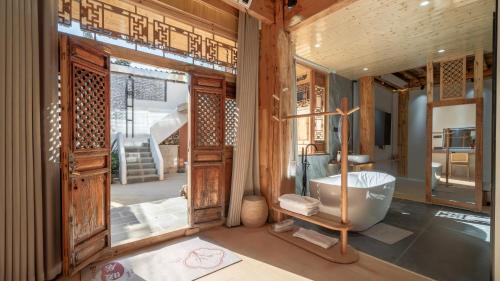 een badkamer met een bad in een kamer bij Nostalgia 28 lodge in Baisha