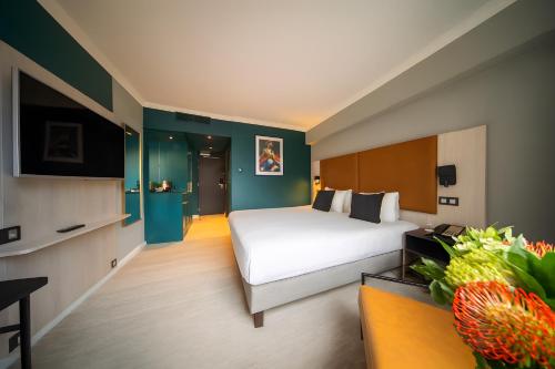 a hotel room with a bed and a tv at Maek Hotel Antwerp Central - Handwritten Collection in Antwerp