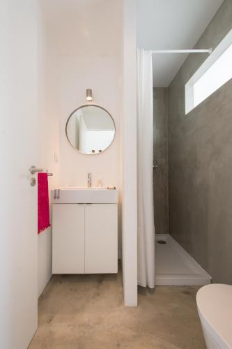 a white bathroom with a sink and a mirror at CASASUPERTUBOS - Apart 1-8 in Atouguia da Baleia