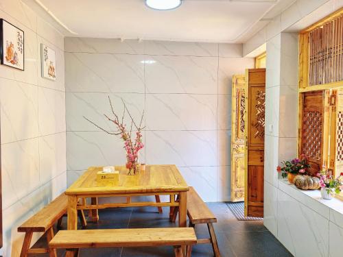 een eetkamer met een houten tafel en banken bij Nostalgia 28 lodge in Baisha