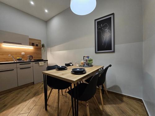 a kitchen with a table and chairs in a room at Gem in City Center in Novi Sad