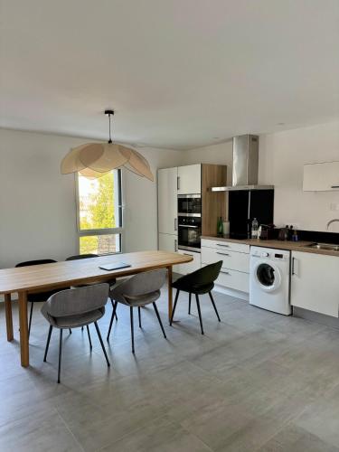 a kitchen with a wooden table and chairs at Duplex en plein coeur de Landerneau in Landerneau