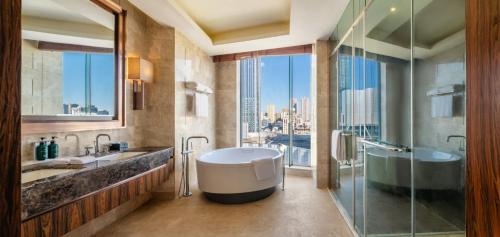 a bathroom with a tub and a glass shower at Crowne Plaza Kunming City Centre by IHG in Kunming