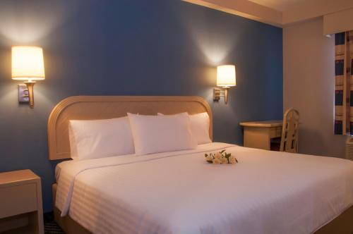 a bedroom with a large bed with two stuffed animals on it at Victoria Inn in Ciudad Victoria