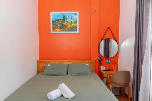 a bedroom with orange walls and a bed and a desk at D Home Da Lat 3 in Da Lat