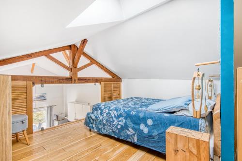 a bedroom with a bed and a wooden floor at La Grange Aux Arbres - Le Tulipier in Baron