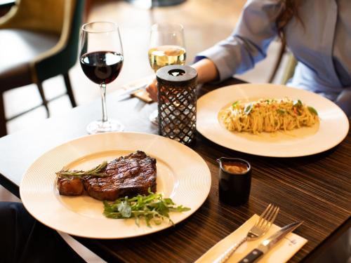 a table with two plates of food and a glass of wine at Lough Erne Resort in Enniskillen