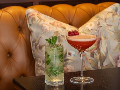 two cocktails sitting on a table with a couch at Lough Erne Resort in Enniskillen