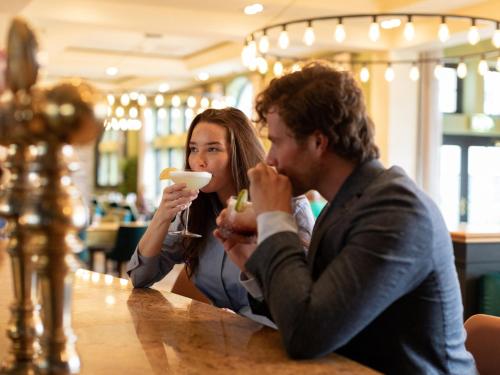 a man and a woman sitting at a table eating food at Lough Erne Resort in Enniskillen