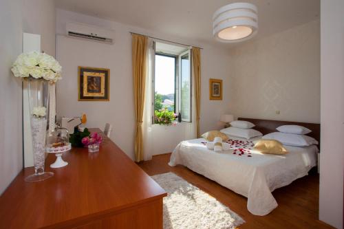 een slaapkamer met een bed en een tafel met bloemen erop bij Luxury Rooms Duje in Split