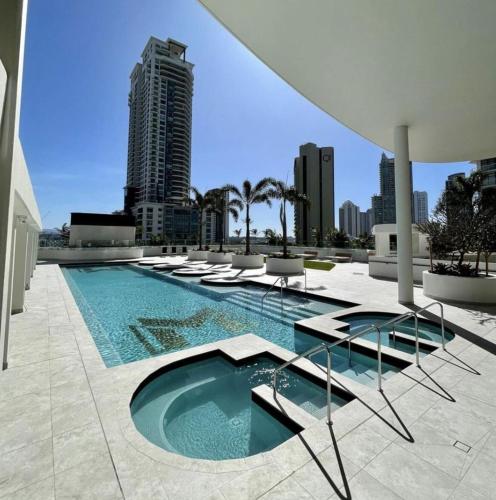 a swimming pool with lounge chairs and a building at 43 Stories High Large Villa with Stunning Ocean Views Pet Friendly in Gold Coast