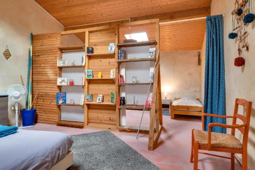 a bedroom with wooden walls and a bed and shelves at Gite Fil Rouge in Saint-Pierre-dʼAurillac
