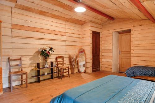 a bedroom with a bed and a table and chairs at Gite Fil Rouge in Saint-Pierre-dʼAurillac