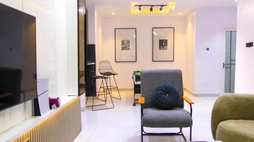 a living room with a chair and a television at CreativeLiving in Mama
