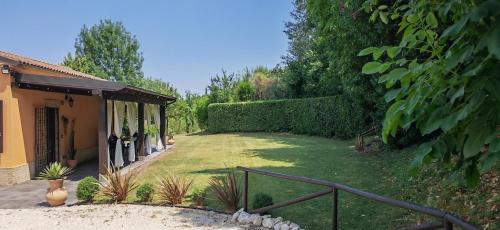 a yard with a fence and a house at La Casa del Bosco in Filottrano