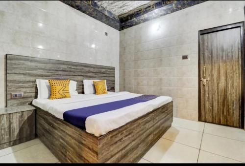 a bedroom with a large bed with a wooden headboard at Ghanshyam Lodge Unit 1 in Ghaziabad