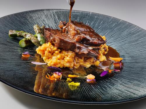 a plate of food with meat and rice and vegetables at Melia Jardines del Teide - Adults Only in Adeje