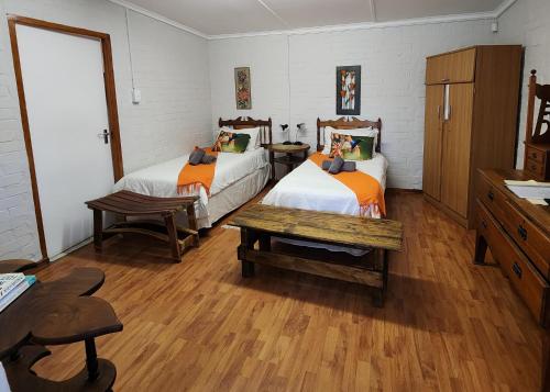 a bedroom with two beds and a wooden floor at Homestead Bed and Breakfast in Addo