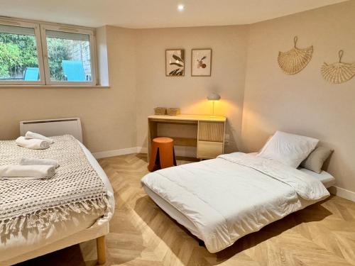 a bedroom with two beds and a desk in it at Le Bohème, Très bel Appartement près de Rennes in Noyal-sur-Vilaine