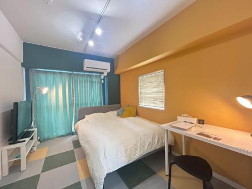 a bedroom with a bed and a desk with a computer at Cube Court 瀬田203 in Otsu