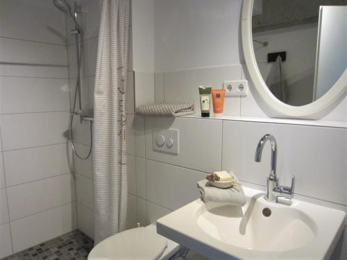 a bathroom with a sink and a toilet and a mirror at K9 Wohnungen in Münster