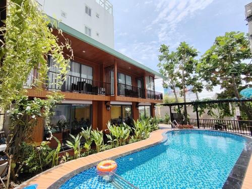 a swimming pool in front of a building at Rosetta Hotel Phu Quoc in Phu Quoc