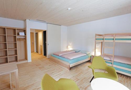 a bedroom with a bed and chairs in a room at St. Moritz Youth Hostel in St. Moritz