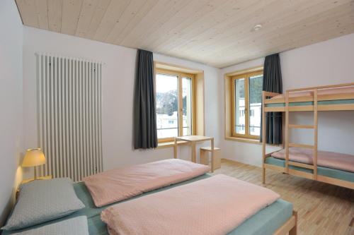 a bedroom with two beds and a window at St. Moritz Youth Hostel in St. Moritz