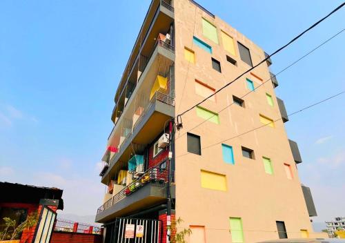a tall building with colorful windows on the side of it at Spatii Apartment in Rishīkesh