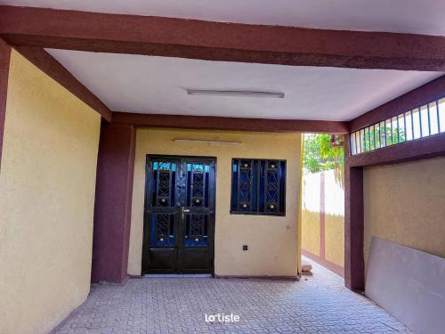 an entrance to a building with blue doors at Superbe mini-villa Ouagadougou in Ouagadougou