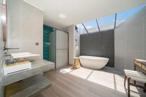 a bathroom with a tub and a toilet and a sink at Howard Johnson by Wyndham Phuket Naiyang in Thalang