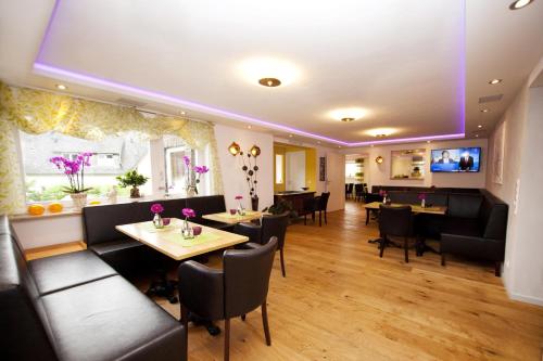 a restaurant with tables and chairs and a flat screen tv at Hotel Vintage Am Bundesbank-Bunker in Cochem