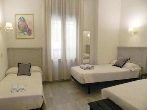 a room with two beds and a window at Hotel Doña Blanca in Seville