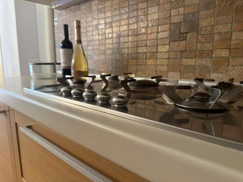 a stove top with a bottle of wine on it at Massone Climbing House - Holiday Home Garda Trentino in Arco