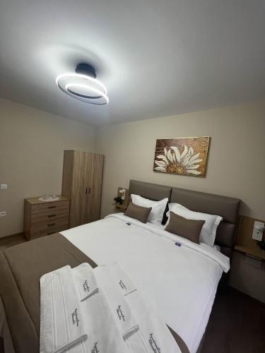 a bedroom with a large white bed and a light at Apartmenthaus Oborishte - 9 in Panagyurishte