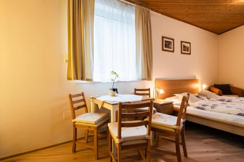a room with a table and chairs and a bed at Alpenpension Haslinger in Bad Gastein