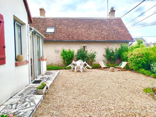a patio with chairs and a table in front of a house at Caporizon - La Solognote in Bracieux