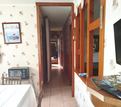 a hallway leading into a room with a tv and a television at Caporizon - La Solognote in Bracieux