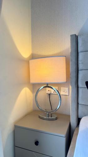 a lamp on a night stand next to a bed at Urban Studio Gem in South B Work Desk Near Airport in Nairobi