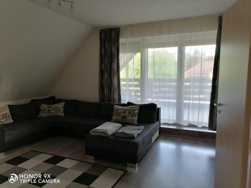 a living room with a couch and a window at Perfekt Apartman Zamárdi in Zamárdi