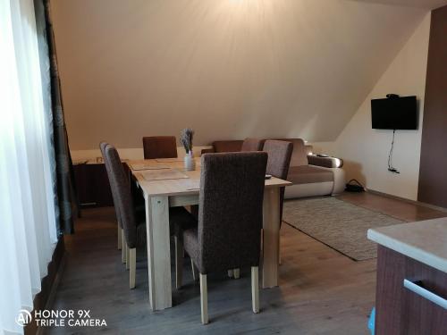 a dining room table with chairs and a couch at Perfekt Apartman Zamárdi in Zamárdi