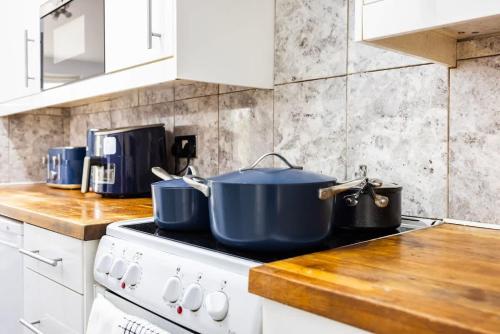 two pots and pans sitting on top of a stove in a kitchen at 4 Bed in Caterham Contractors Leisure in Purley