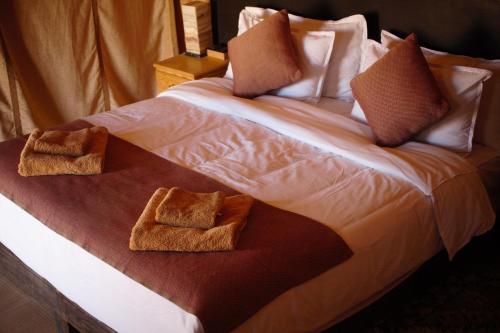 a large bed with two towels on it at Camel Luxury Camp in Merzouga