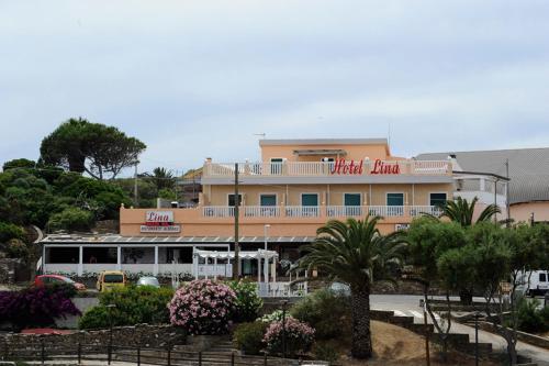a hotel building with a sign on top of it at Lina Hotel in Stintino