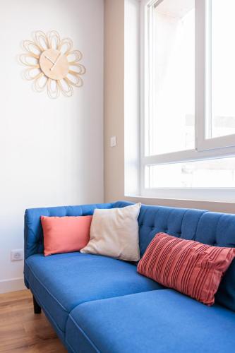 a blue couch with pillows on it in a room at Le cocon du Centre in Dunkerque