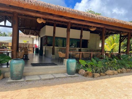 a pavilion with blue vases in front of a restaurant at Pineapple Beach Villas in Baie Lazare Mahé