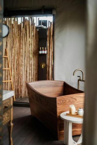 a wooden bath tub in a bathroom with a table at Nekajui, a Ritz-Carlton Reserve in Papagayo, Guanacaste